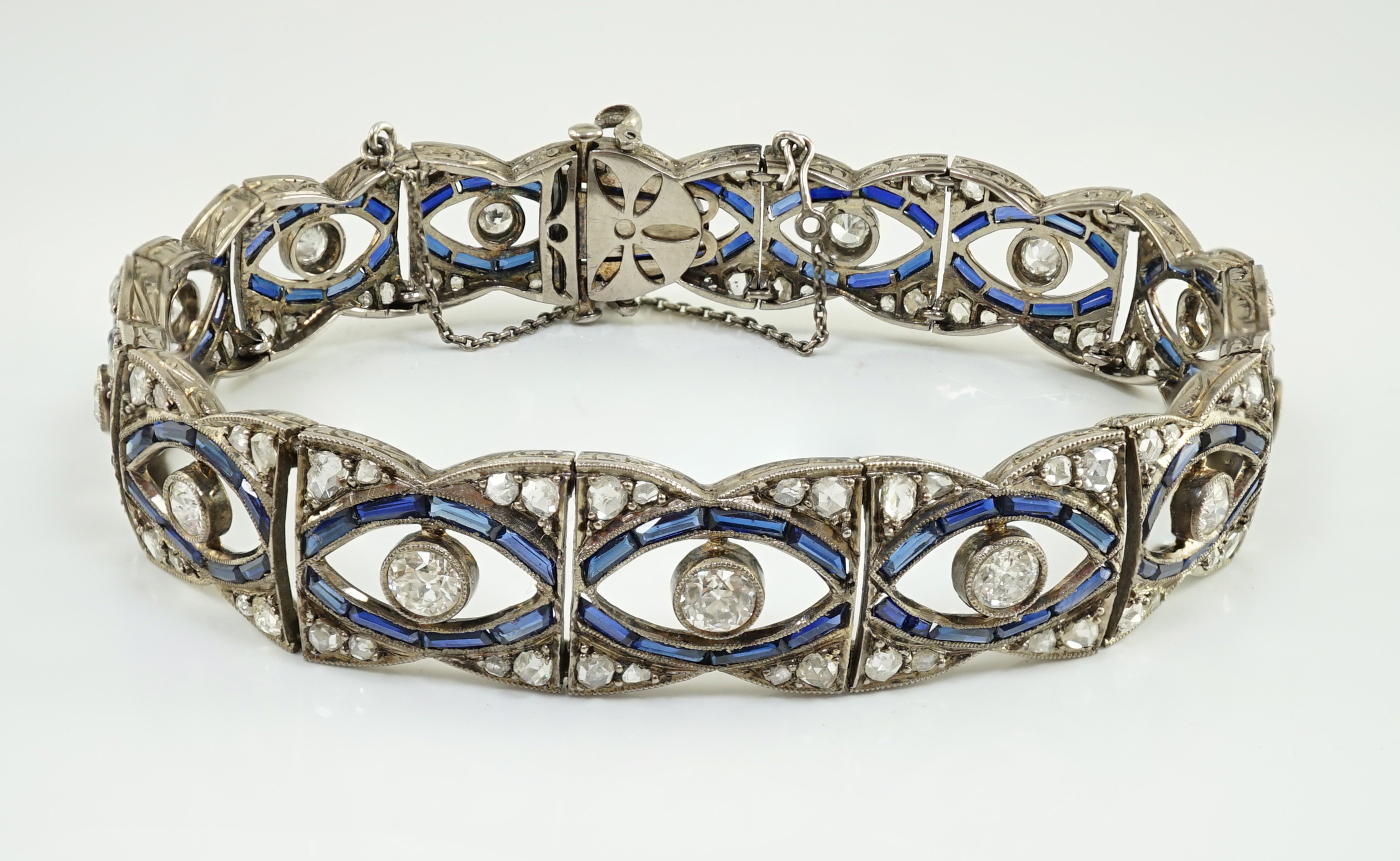 A 1920's 18ct white gold and millegrain set synthetic? sapphire and round and rose cut diamond set bracelet, with safety chain